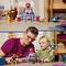 Eine erwachsene Person und ein Kind spielen gemeinsam mit einer bunten LEGO-Spielfigur, die eine Superhelden-Themenwelt darstellt.