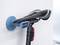 Ein Fahrrad ist mit seinem Sattel an einer Wandhalterung befestigt. Die Halterung ist blau, der Sattel schwarz und das Fahrrad steht senkrecht.