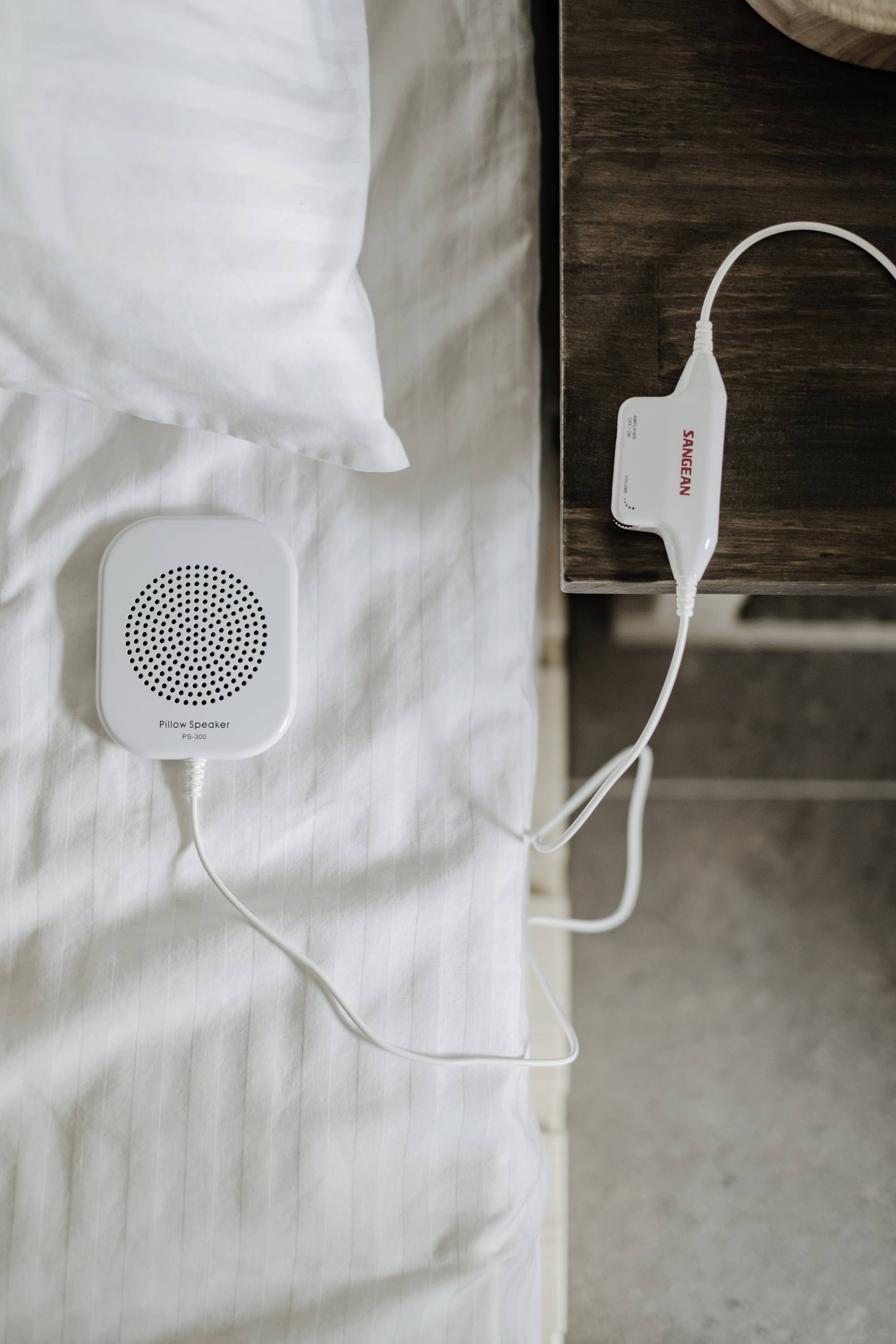 Gerät zur Überwachung mit Kabelverbindung neben einem Bett, auf einem Nachttisch platziert.