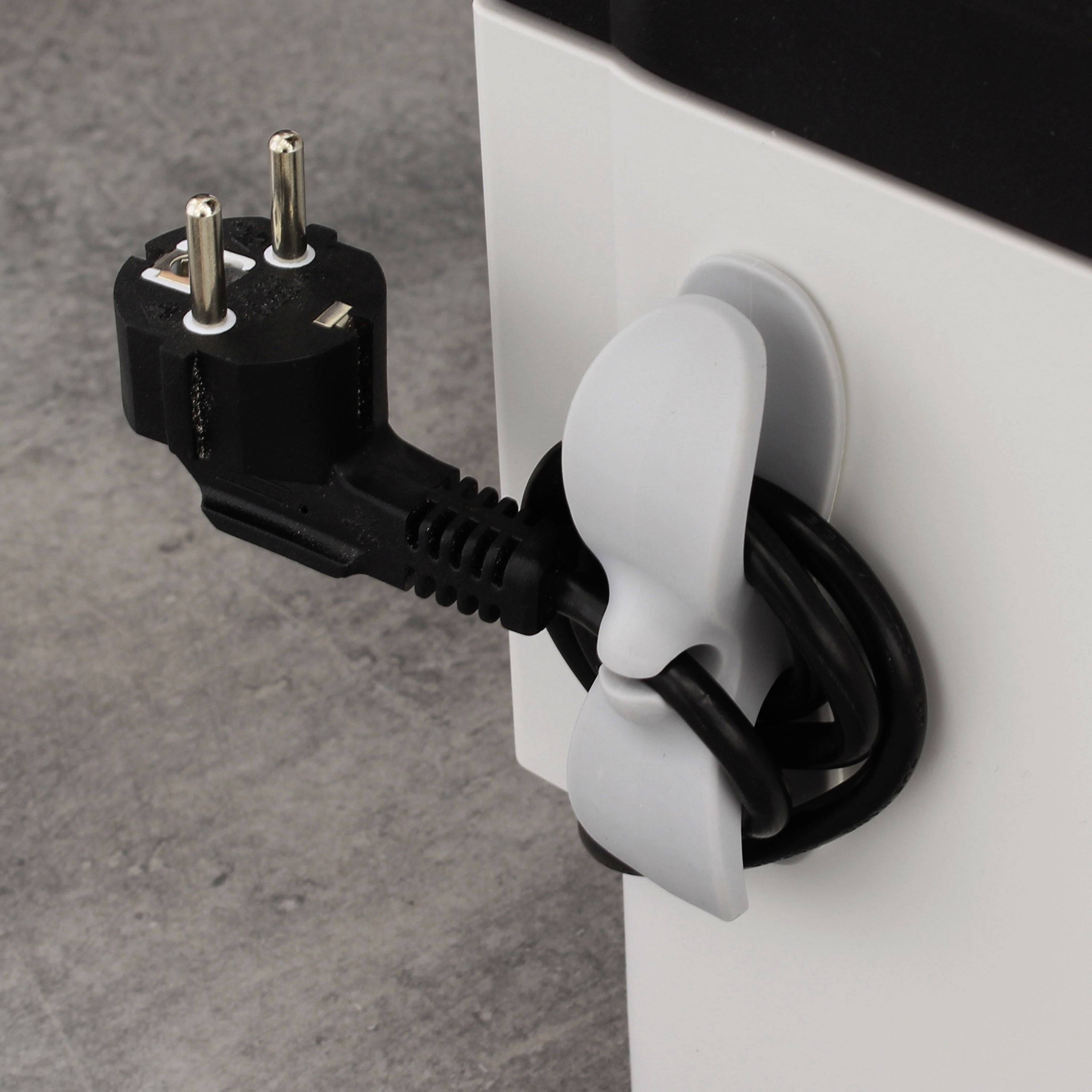 Ein graues Kabel ist mithilfe eines weißen Kabelhalters ordentlich um einen Tischbein gewickelt. Ein schwarzer Stecker ist eingesteckt.