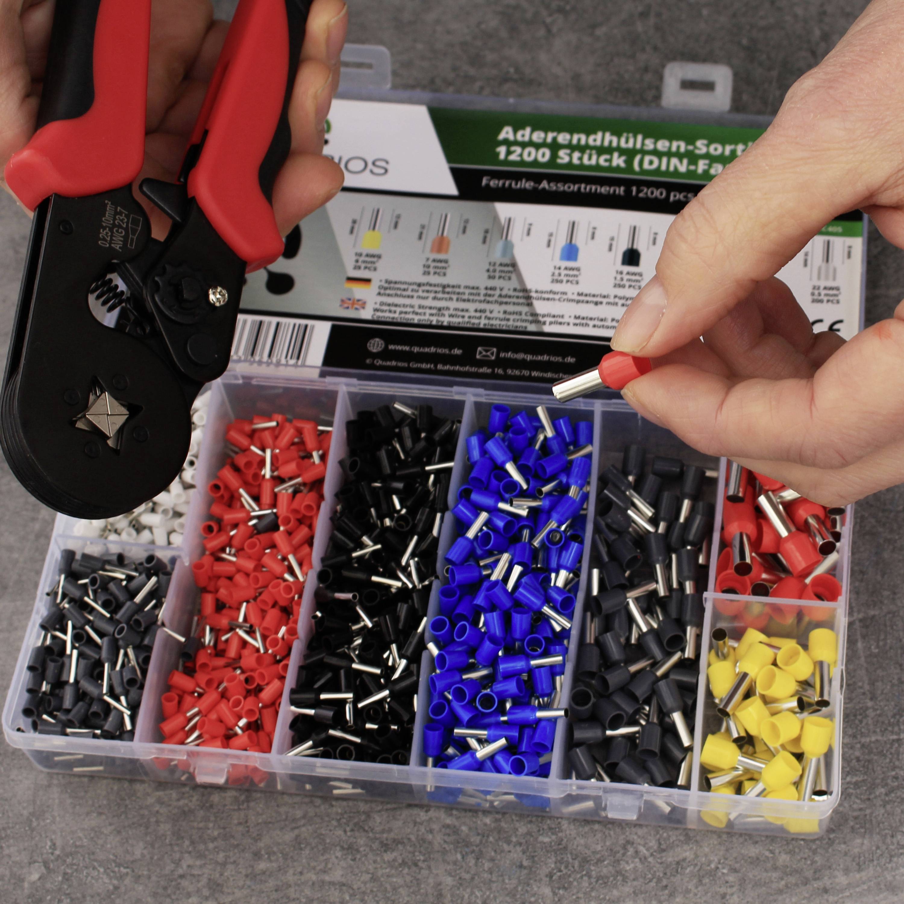 Eine Person hält einen roten Aderendhülsen-Assortimentskasten. Verschiedene Farben und Größen von Aderendhülsen sichtbar.