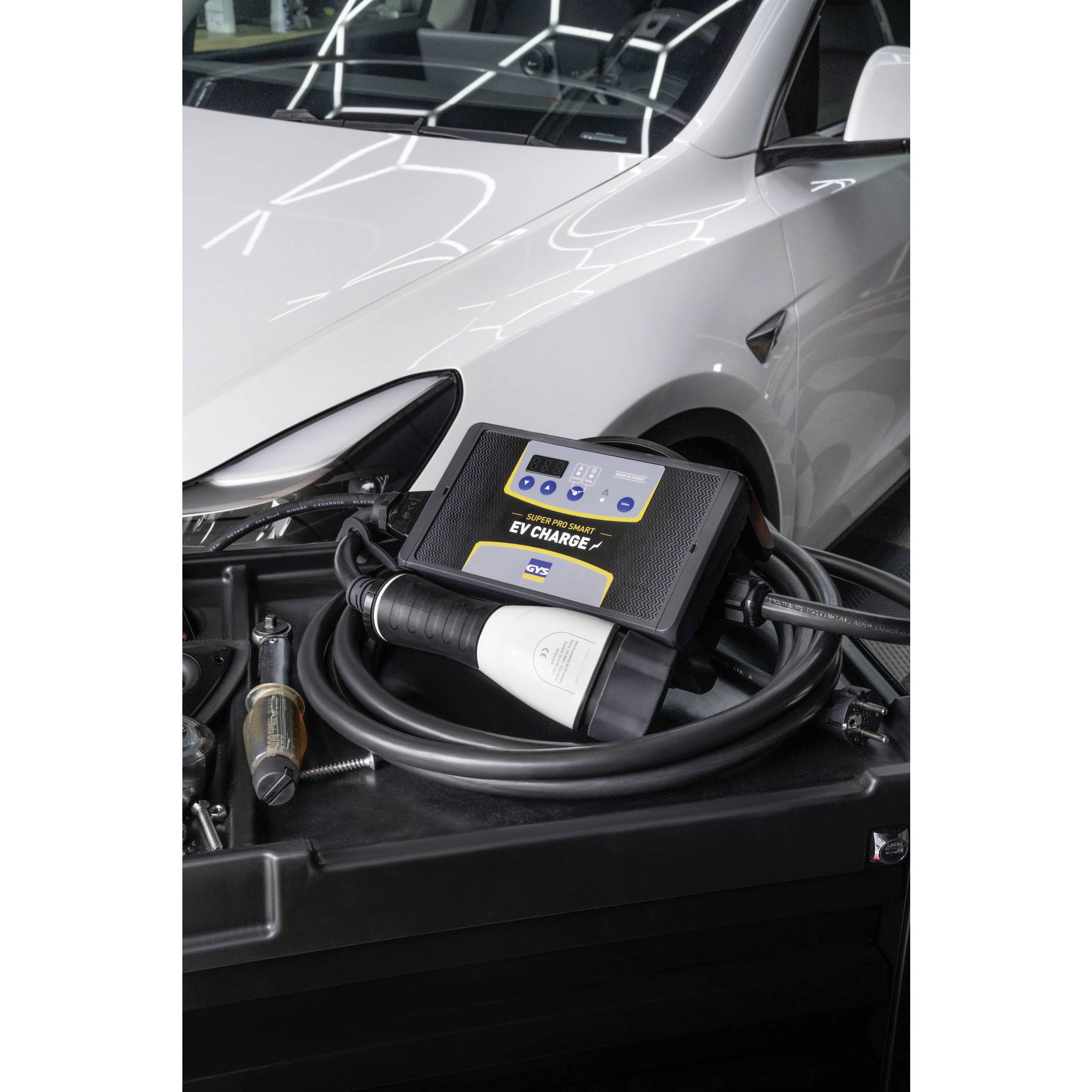 Ein Elektroauto wird an einem Ladekabel mit einer Ladestation aufgeladen. Die Ladestation zeigt den Ladefortschritt an.