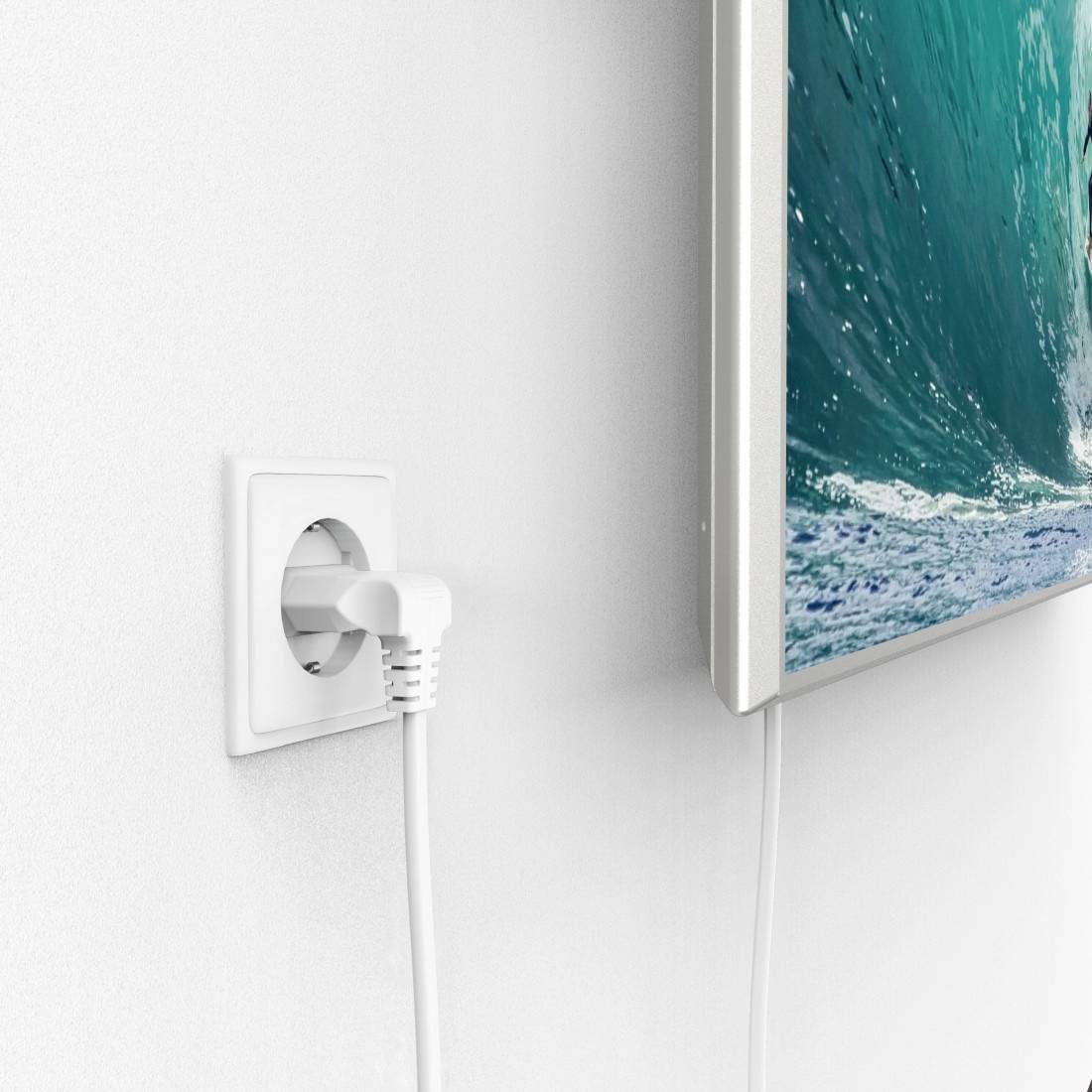 Ein Stecker steckt in einer weißen Wandsteckdose. Daneben hängt ein Bild an der Wand, das eine große Meereswelle zeigt.