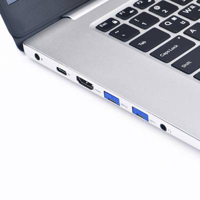 Silberner Laptop mit schwarzer Tastatur, gezeigt von der Seite. Zu sehen sind USB-Anschlüsse, ein HDMI-Ausgang und ein Kopfhöreranschluss.