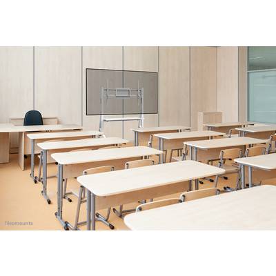Klassenzimmer mit leeren Schreibtischen und Stühlen. Vorne ein Lehrerpult mit Stuhl, im Hintergrund ein Bildschirmständer.