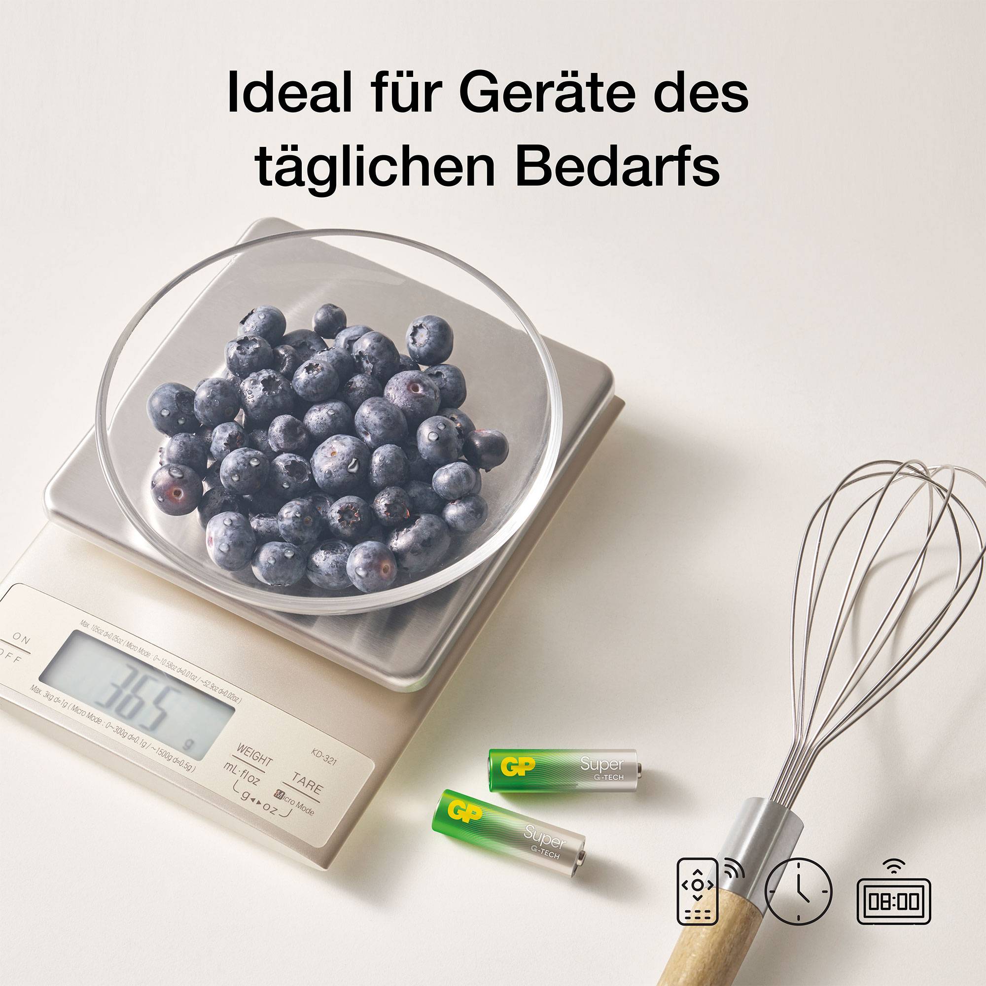 Eine Schale Blaubeeren steht auf einer Küchenwaage, die 165 Gramm anzeigt. Daneben liegen Batterien und ein Schneebesen. Text: 'Ideal für Geräte des täglichen Bedarfs'.
