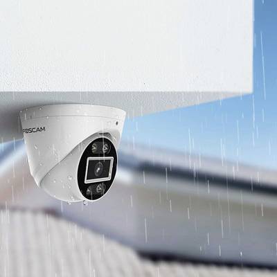 Überwachungskamera an einer Gebäudeecke bei Regenwetter installiert, fokussiert auf Sicherheitsüberwachung bei unterschiedlichen Wetterbedingungen.