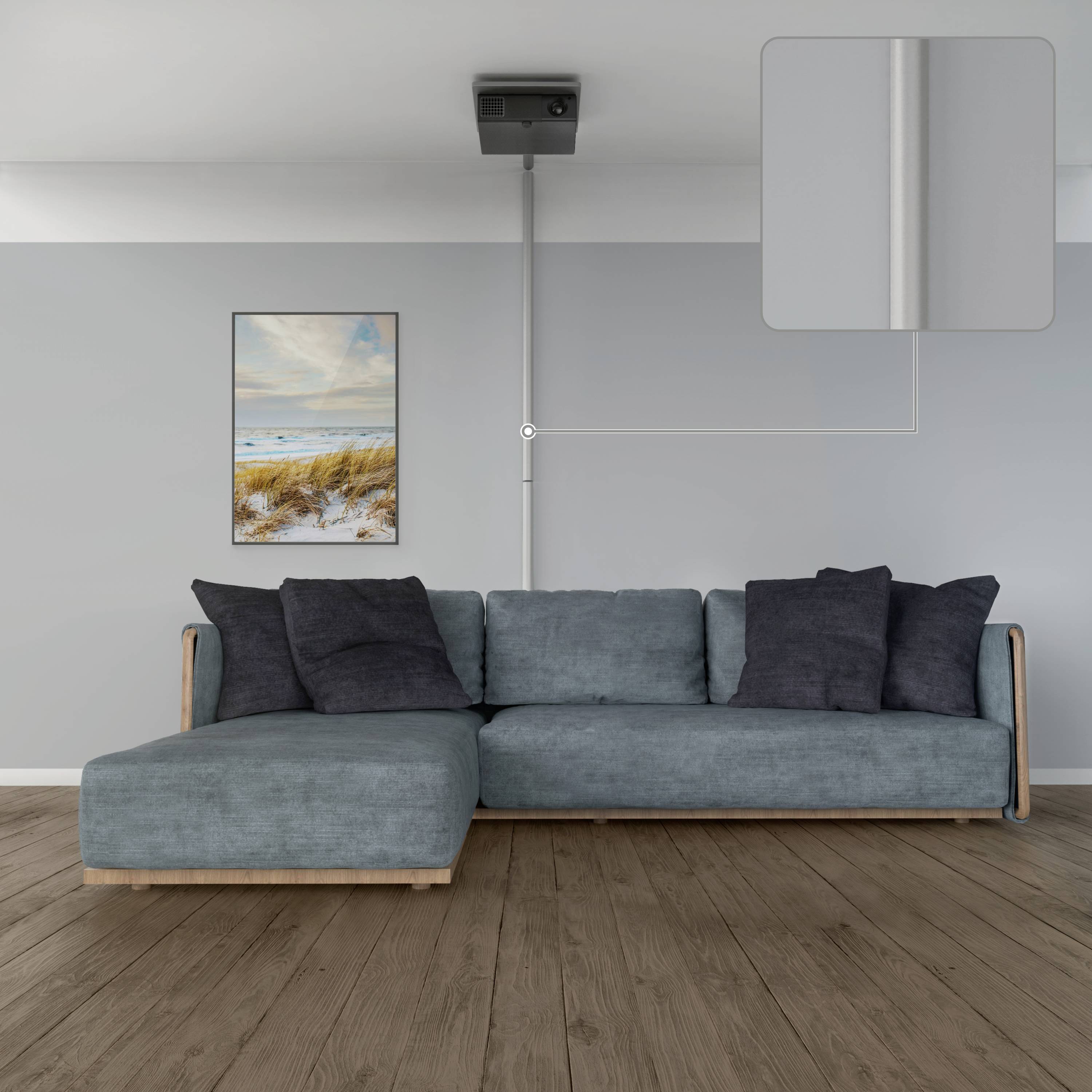 Graues Wohnzimmer mit blauem Sofa und schwarzem Kissen; an der Wand ein Strandbild. Dunkler Holzboden und eine Deckenleuchte.