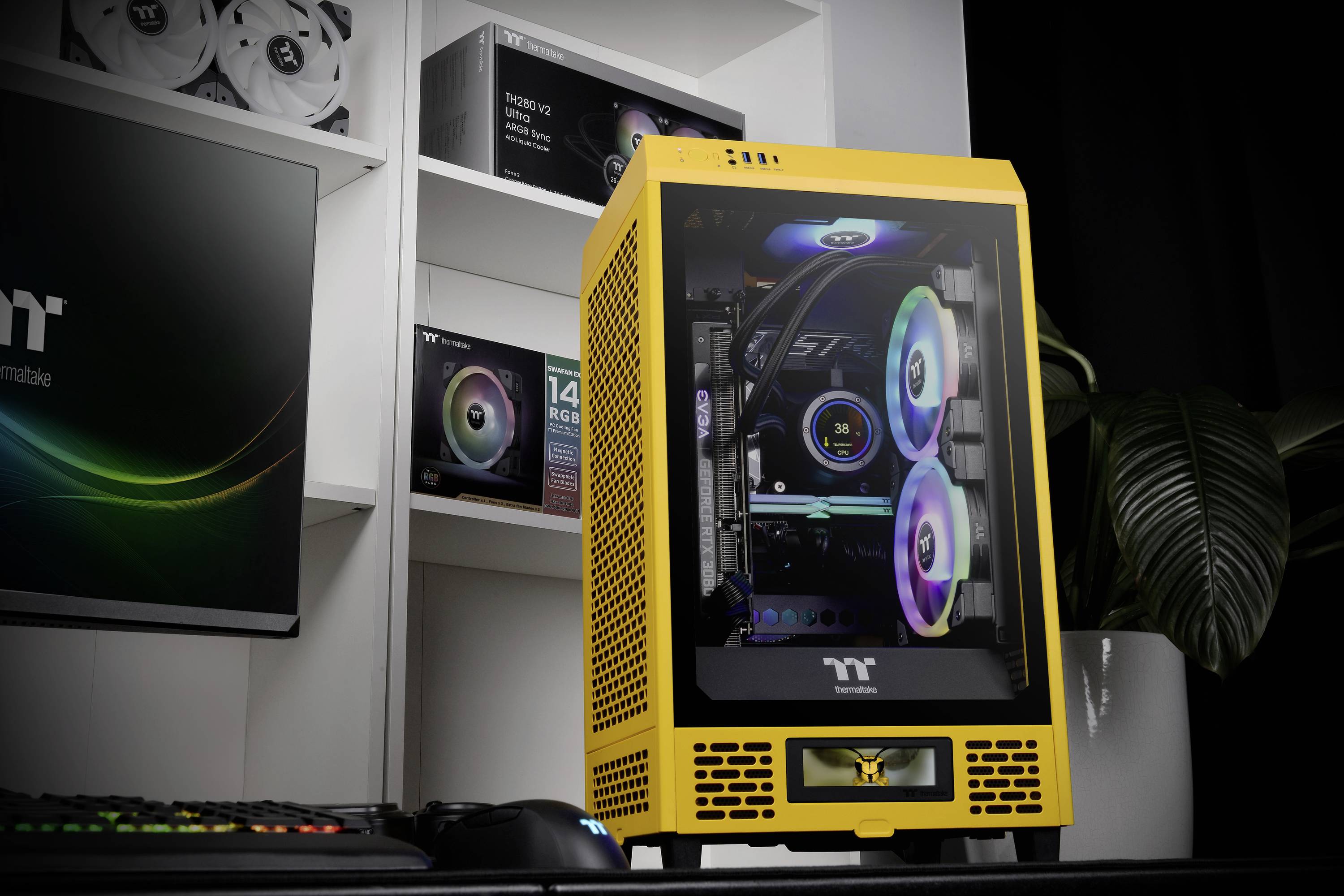 Ein gelbes Computergehäuse mit Glasfenster zeigt bunte Leuchtrahmen. Im Hintergrund sind weitere Computerkomponenten auf Regalen sichtbar.