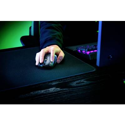 Eine Person benutzt eine Gaming-Maus auf einem Mauspad neben einer beleuchteten Tastatur.