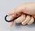 Eine Hand hält ein schwarzes Kabel, das in einer Schleife gebogen ist.