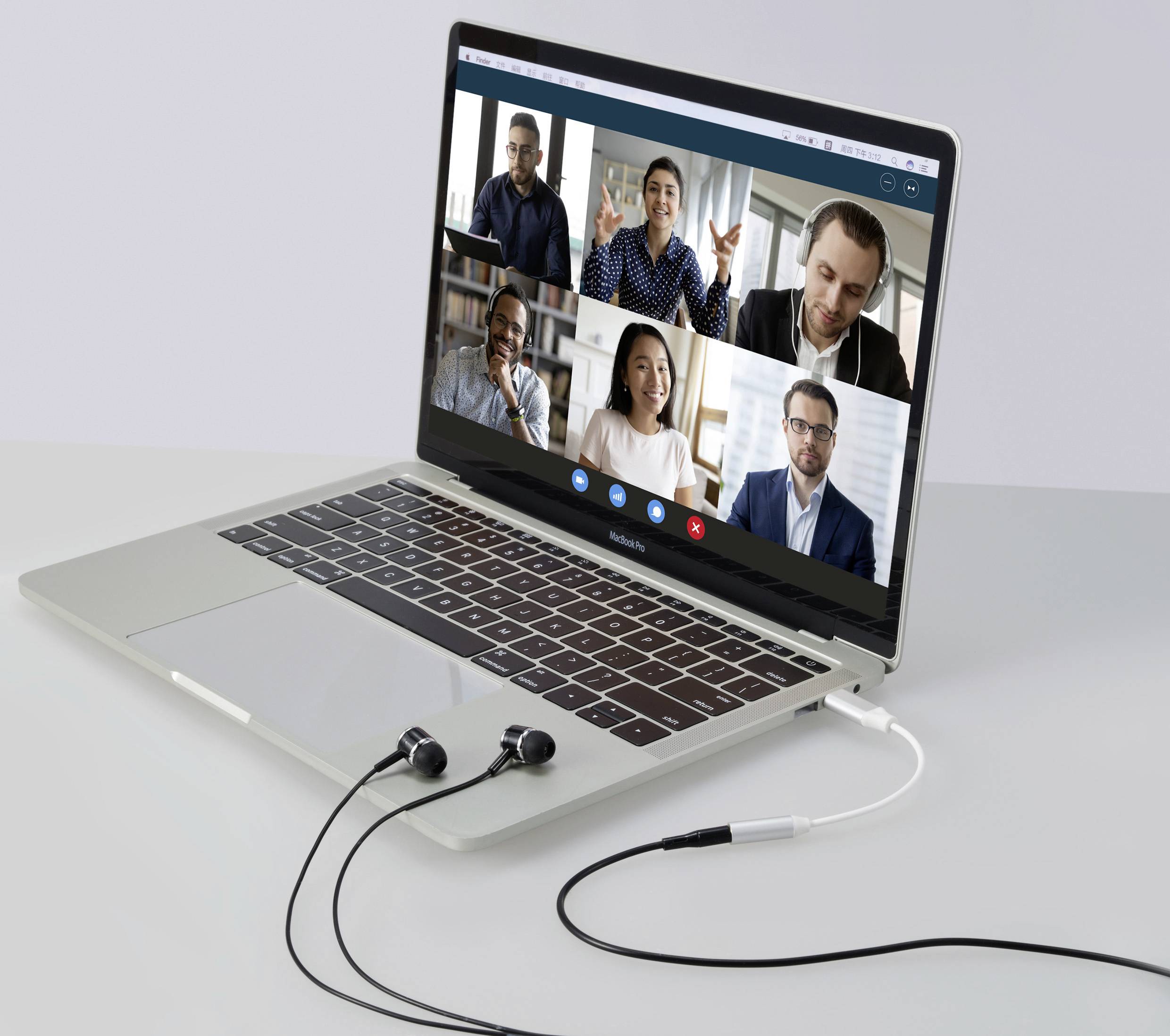 Ein Laptop zeigt einen Videoanruf mit sechs Personen in einem virtuellen Meeting. Kopfhörer sind angeschlossen.