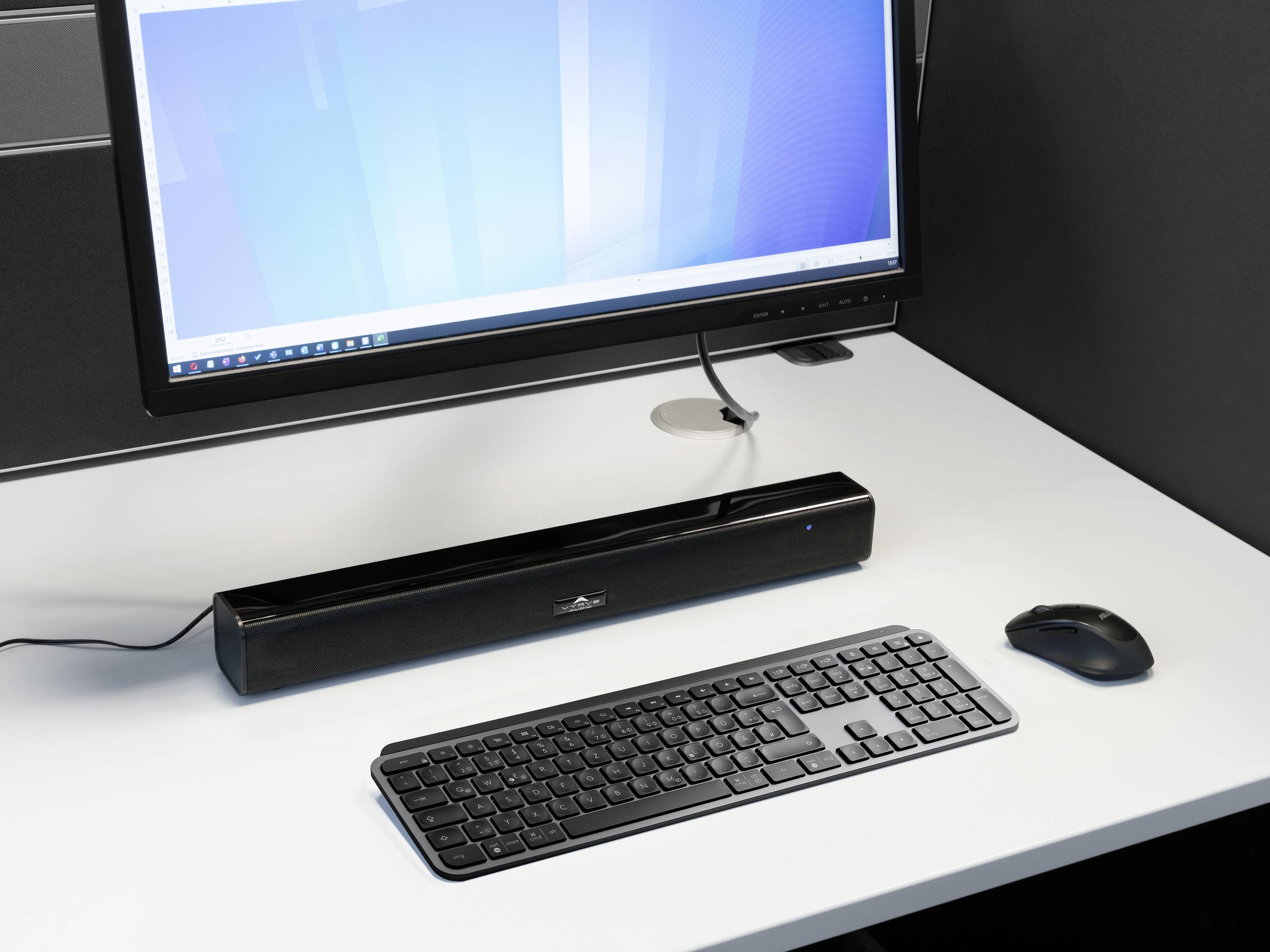 Ein Computerbildschirm zeigt einen blauen Hintergrund. Auf dem Schreibtisch befinden sich eine Tastatur und eine Maus.