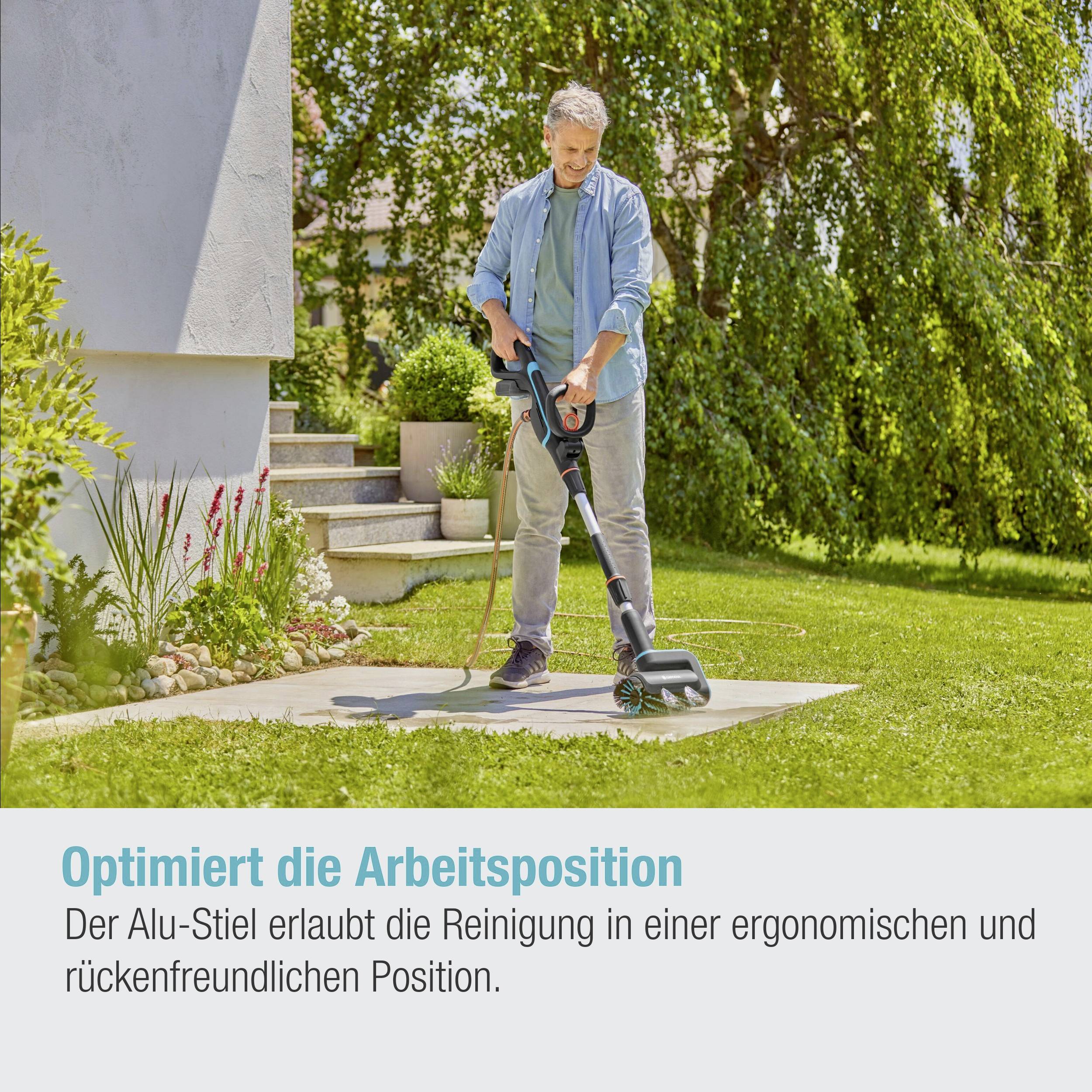 Eine Person mäht den Rasen mit einem ergonomischen Rasenmäher neben einem modernen Gebäude. Der Text hebt die ergonomische Arbeitshaltung hervor.