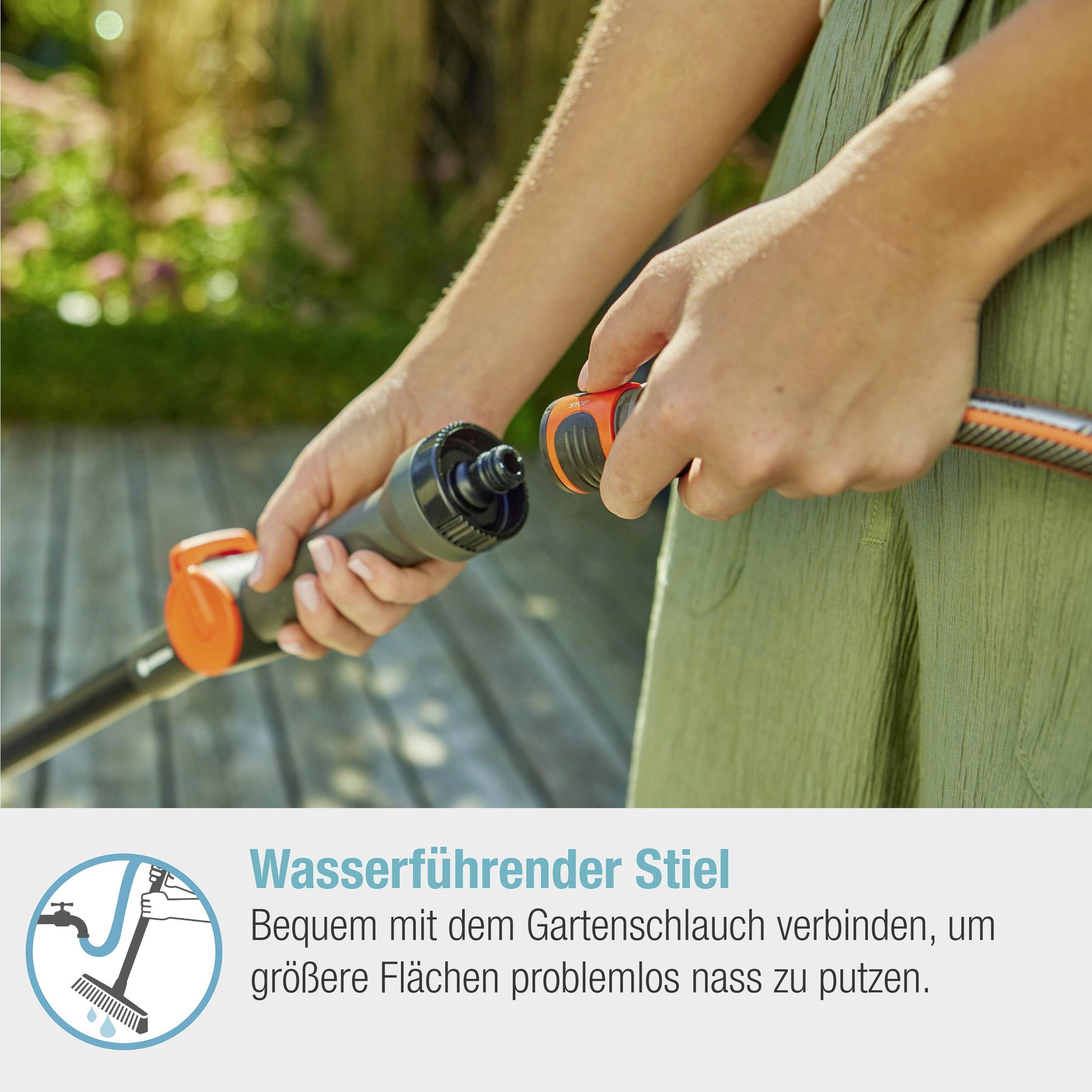 Person hält einen Gartenschlauch mit wasserführendem Stiel, ideal zum problemlosen Nassreinigen großer Flächen im Garten oder Hof.