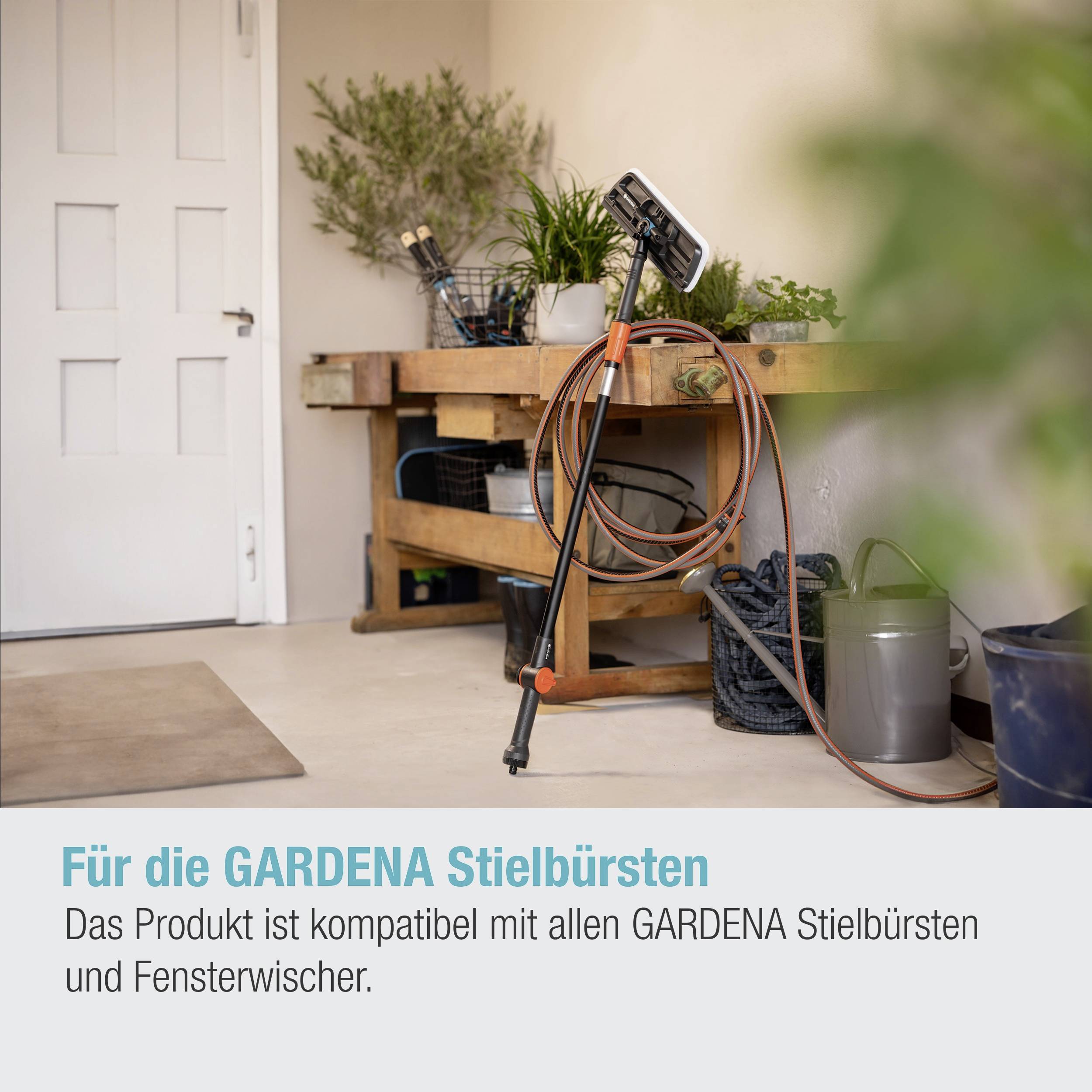 Ein Garten-Set mit Schläuchen und Zubehör auf einem Tisch nahe einer Tür; Text: 'Das Produkt ist kompatibel mit allen GARDENA Stielbürsten und Fensterwischer.'