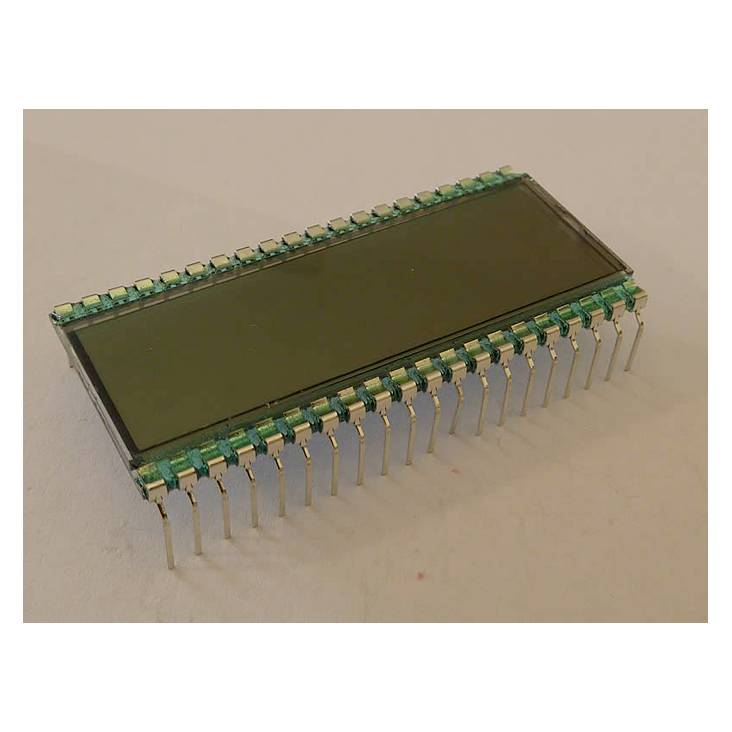 Ein rechteckiger Mikrochips mit mehreren Metallpins an den Seiten, liegt auf einer hellen Oberfläche.