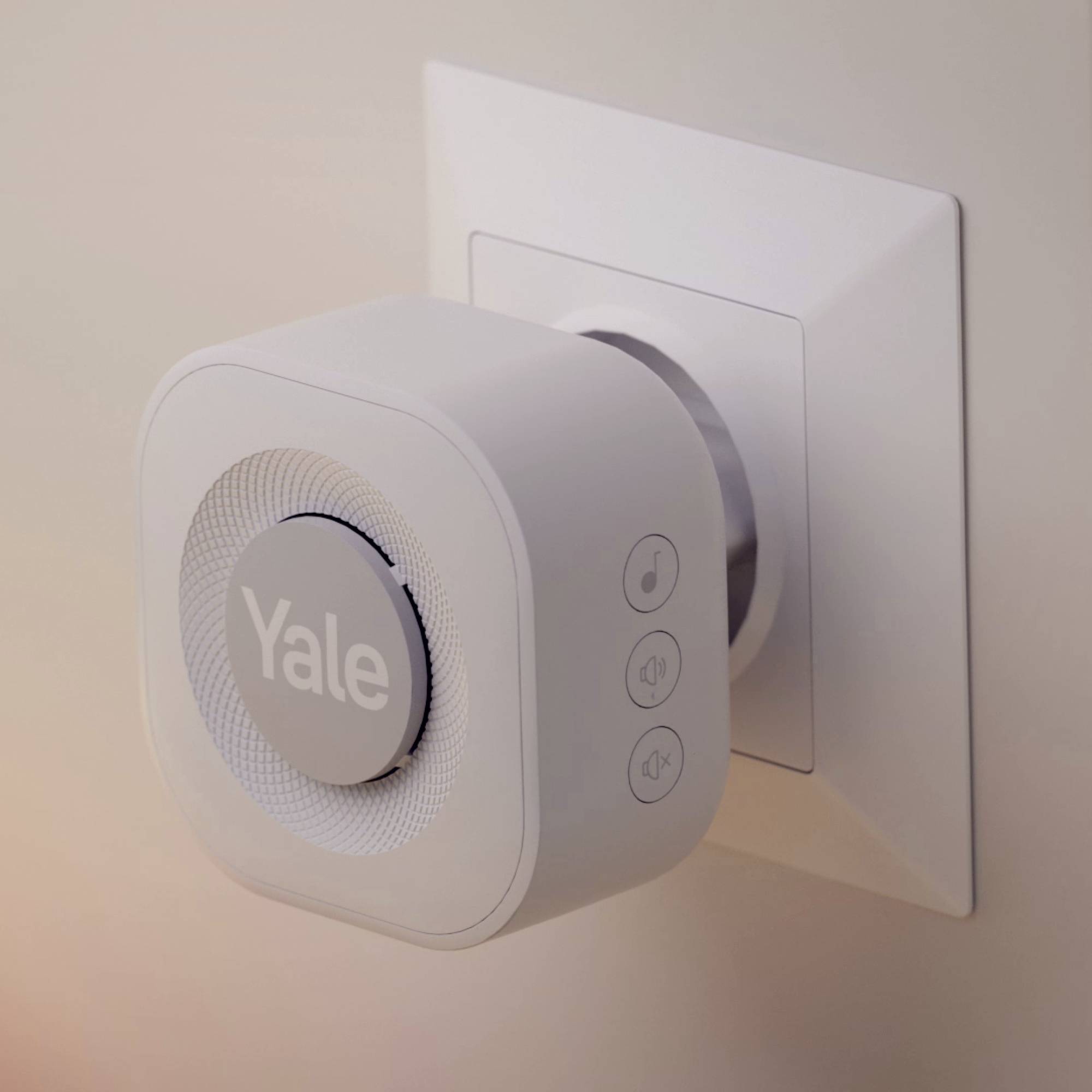 Ein elektronisches Türschloss mit rundem, weißem Gehäuse und der Aufschrift 'Yale', montiert an einer Wandaufnahme.