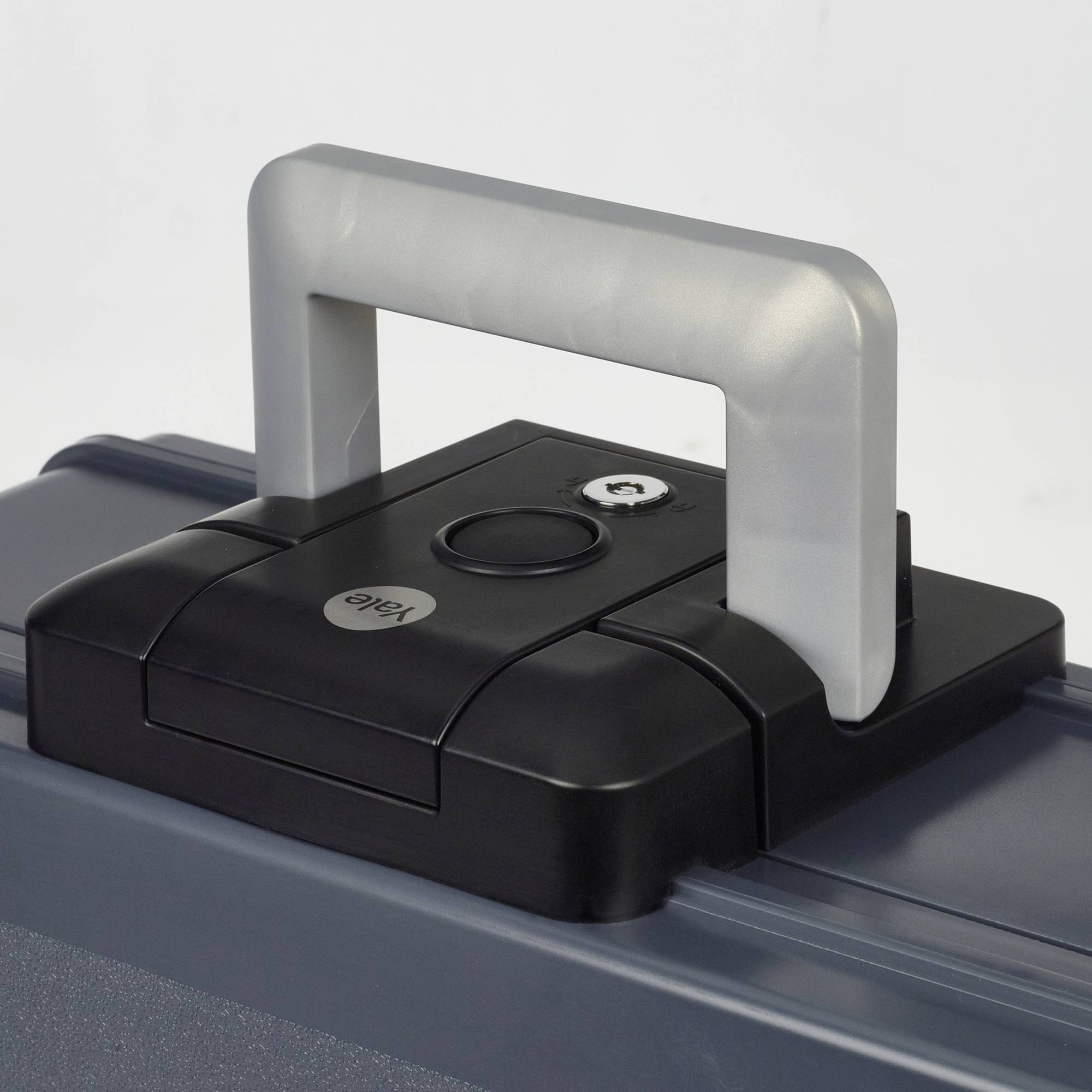 Ein grauer Koffer mit einem silbernen und schwarzen Griff, der sich horizontal an der Oberseite befindet. Ein Schlüsselloch ist sichtbar.