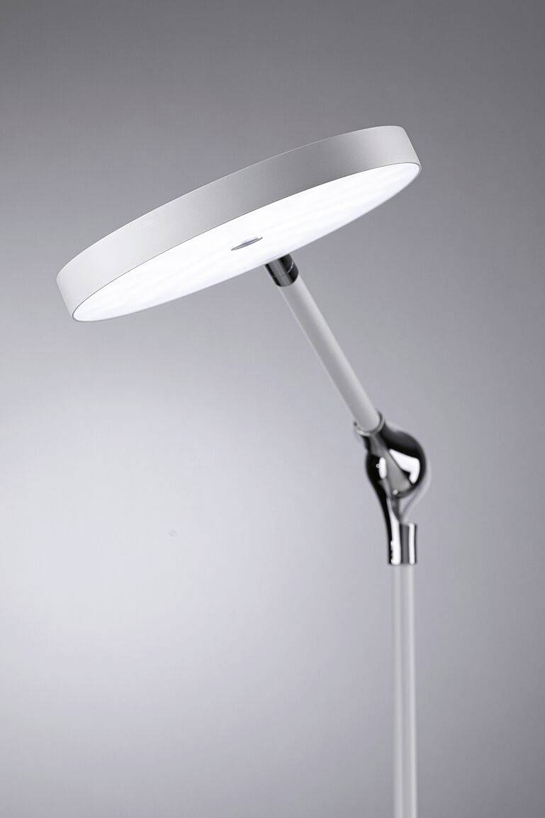 Eine moderne Stehlampe mit rundem, weißem Lampenschirm, der geneigt ist. Der Hintergrund ist grau.