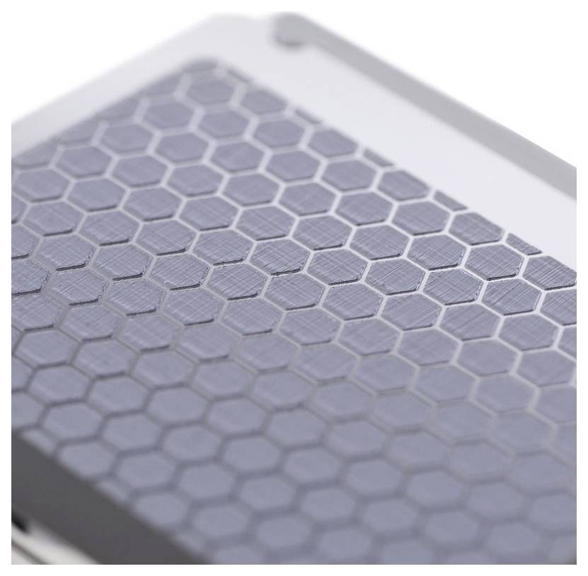 Nahaufnahme einer metallischen Oberfläche mit sechseckigem, wabenartigem Muster.