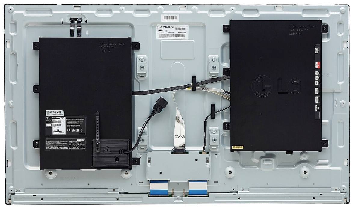 Die Rückseite eines großen elektronischen Geräts mit zwei abgedeckten Modulen, Kabelverbindungen und Etiketten für technische Spezifikationen.