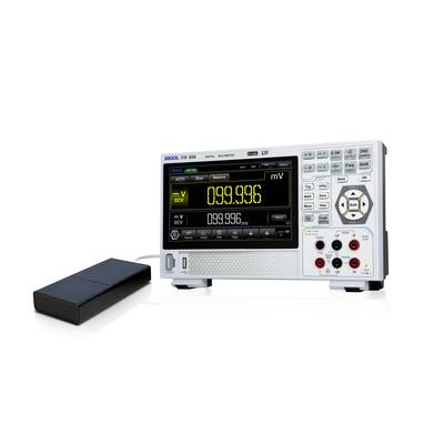 Ein digitales Multimeter zeigt eine Spannung von 99,996 Millivolt an. Neben dem Gerät liegt eine schwarze Sonde.
