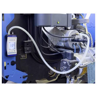 Eine technische Einrichtung, die ein Manometer mit der Anzeige '1104' zeigt, das mit Maschinen durch Kabel und Schläuche verbunden ist, möglicherweise Teil eines industriellen Systems.