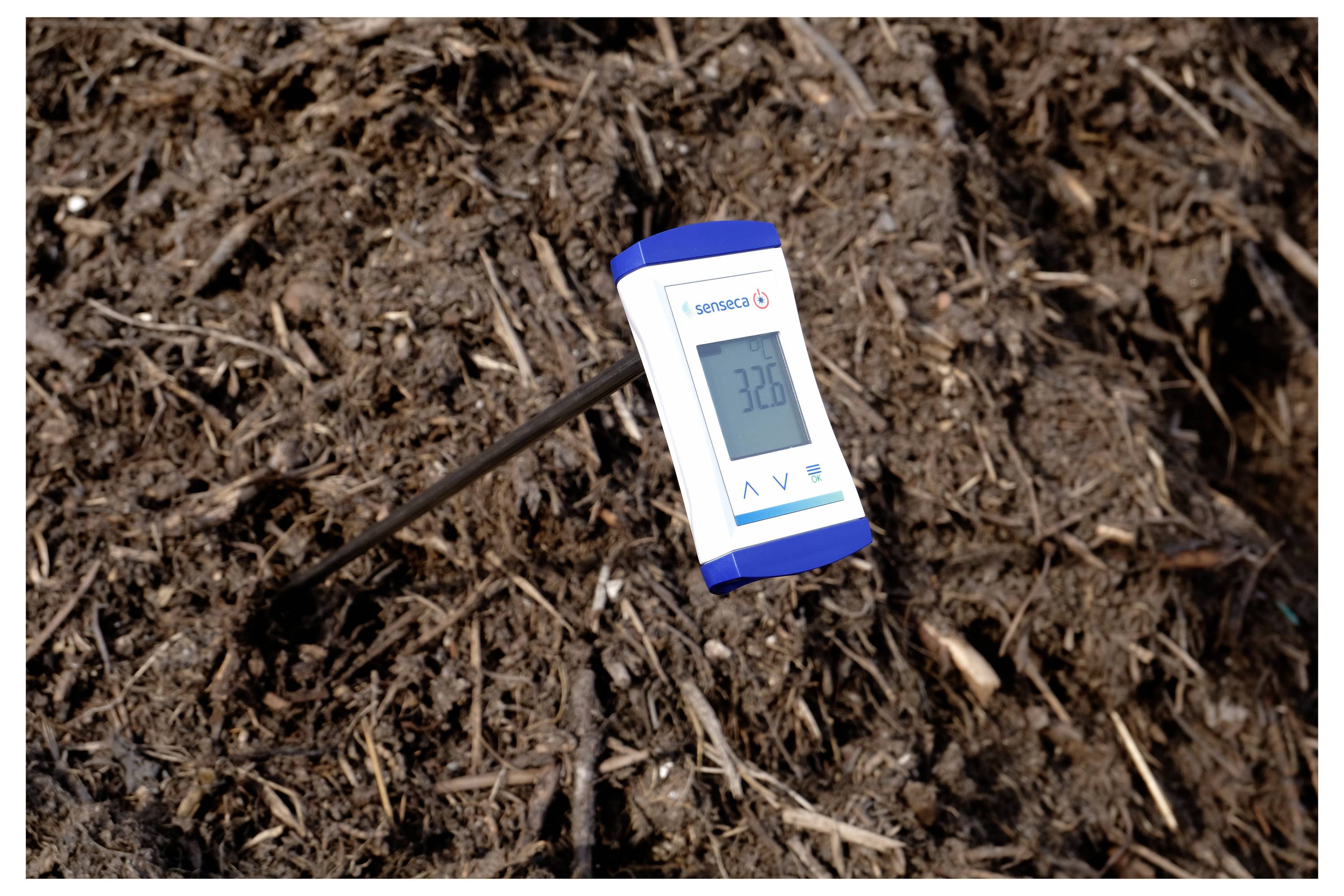 Ein digitales Thermometer, das in den Boden eingesetzt ist und eine Anzeige von '32,8' Grad zeigt, möglicherweise zur Messung der Bodentemperatur.