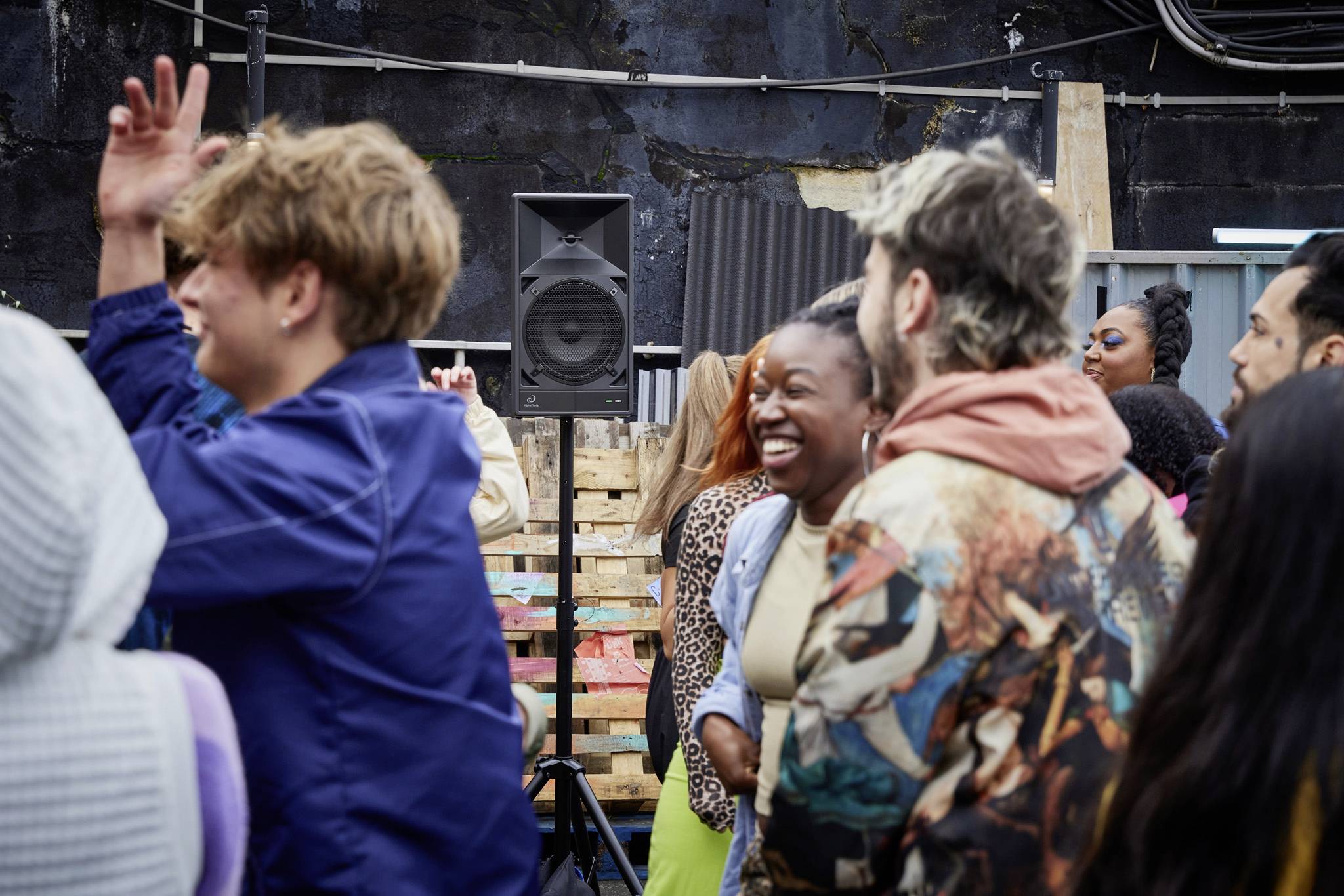 Menschen feiern und tanzen fröhlich bei einer Outdoor-Veranstaltung. Sie lachen und genießen die gemeinsame Zeit miteinander.