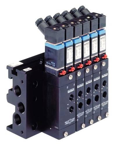 Mehrere schwarze Solenoidventile in einer Reihe montiert, mit blauen Etiketten und rotem Schalter, für industrielle Anwendungen geeignet.