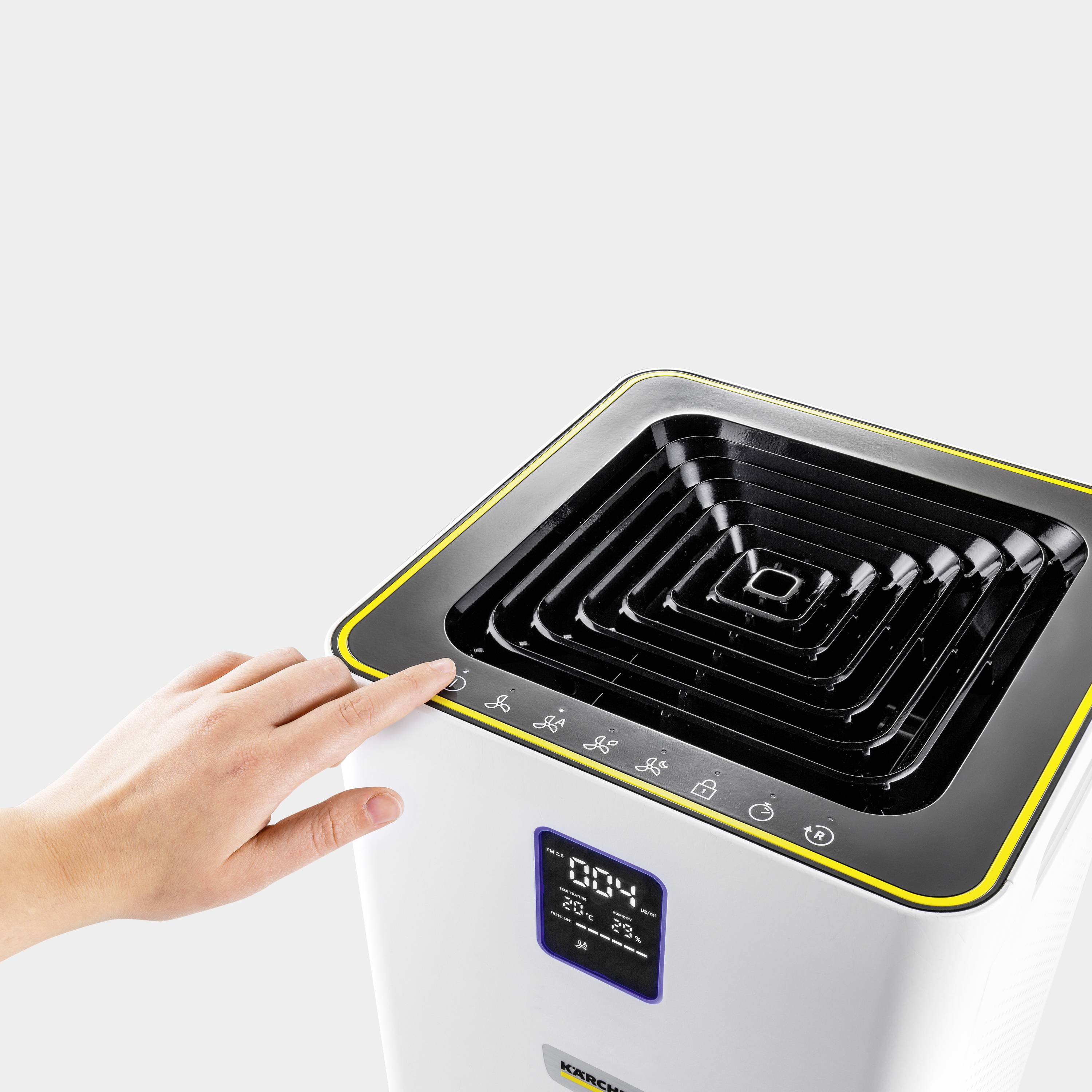 Eine Hand nähert sich einem Luftreiniger mit digitalem Display. Das Display zeigt 20°C und 45% Luftfeuchtigkeit an.