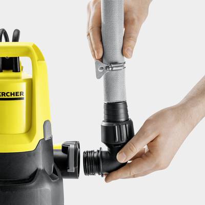 Eine Person verbindet einen grauen Schlauch mit einem gelben Industriestaubsauger.
