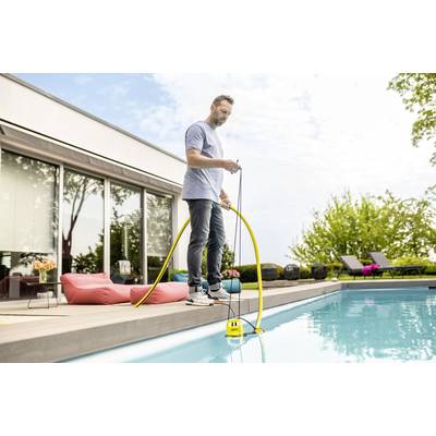 Ein Mann steht am Poolrand und benutzt eine gelbe Pumpe, um das Wasser im Pool zu reinigen. Im Hintergrund sind Sitzgelegenheiten und Bäume.