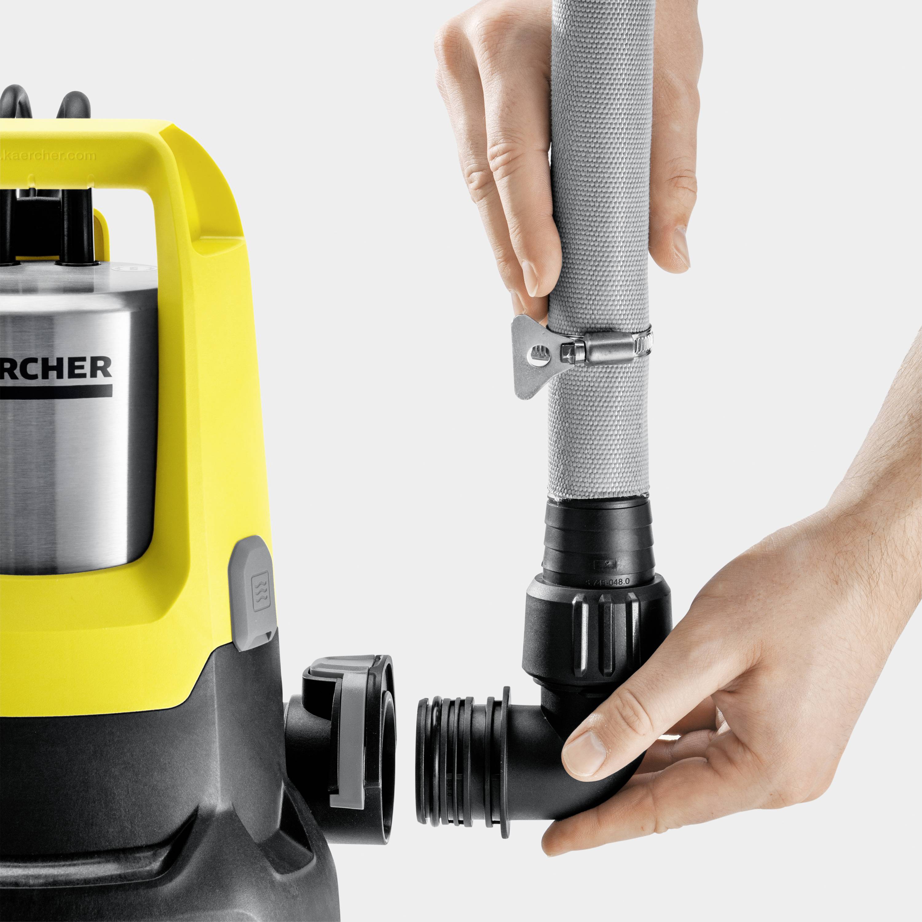 Eine Hand hält den Schlauch einer gelben Wasserpumpe und schraubt einen Anschluss an.