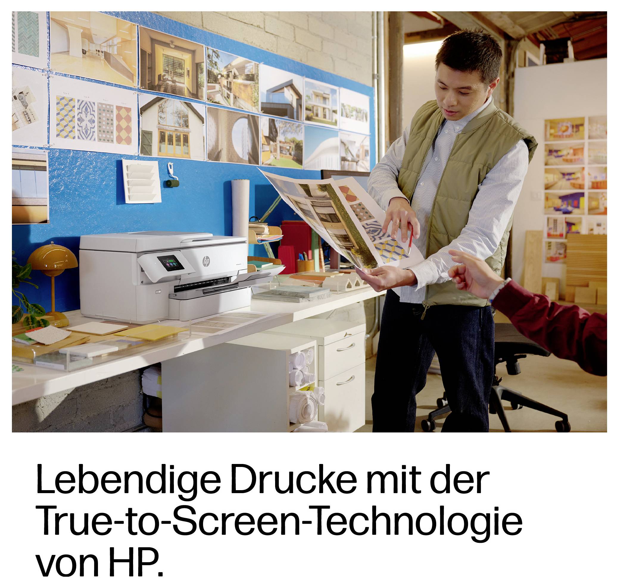 Ein Mann zeigt auf einen Magazin-Proof neben einem HP-Drucker in einem Design-Studio und zeigt damit die "True-to-Screen Technology" für lebendige Drucke.