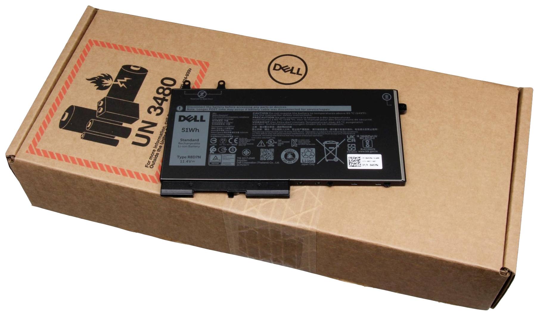 Ein Dell Laptop-Akku liegt auf einem braunen Versandkarton mit Warnsymbolen für Lithium-Ionen-Batterien.