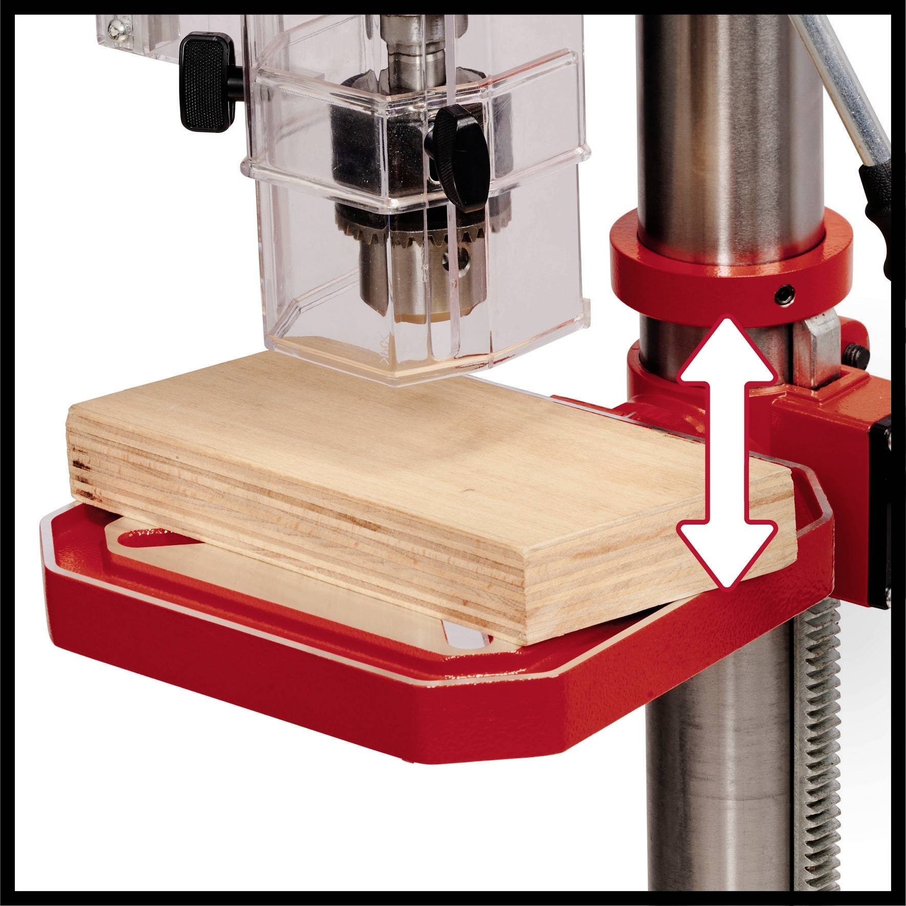 Eine Bohrmaschine bearbeitet ein Holzbrett. Ein Pfeil zeigt die Höhenverstellbarkeit an, die Maschine hat rote und silberne Teile.