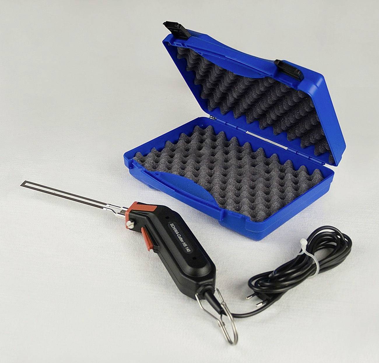 Ein elektronisches Gerät mit einem langen Metallstab und Kabel, platziert neben einer blauen Schutzhülle mit Schaumstoff-Innenpolsterung.