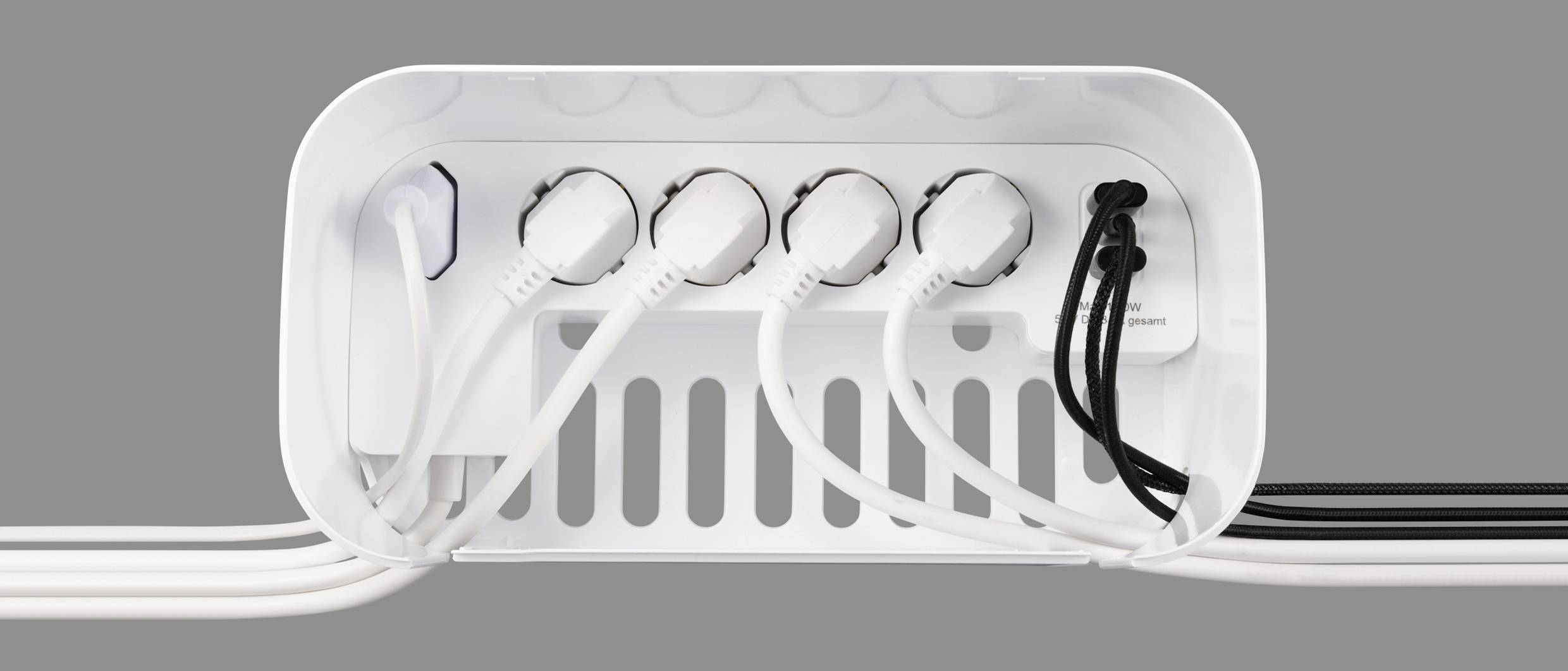 Ein weißes Kabelmanagement-Box mit mehreren geordneten Kabeln und Steckern, die ordentlich hineingelegt sind, vor grauem Hintergrund.