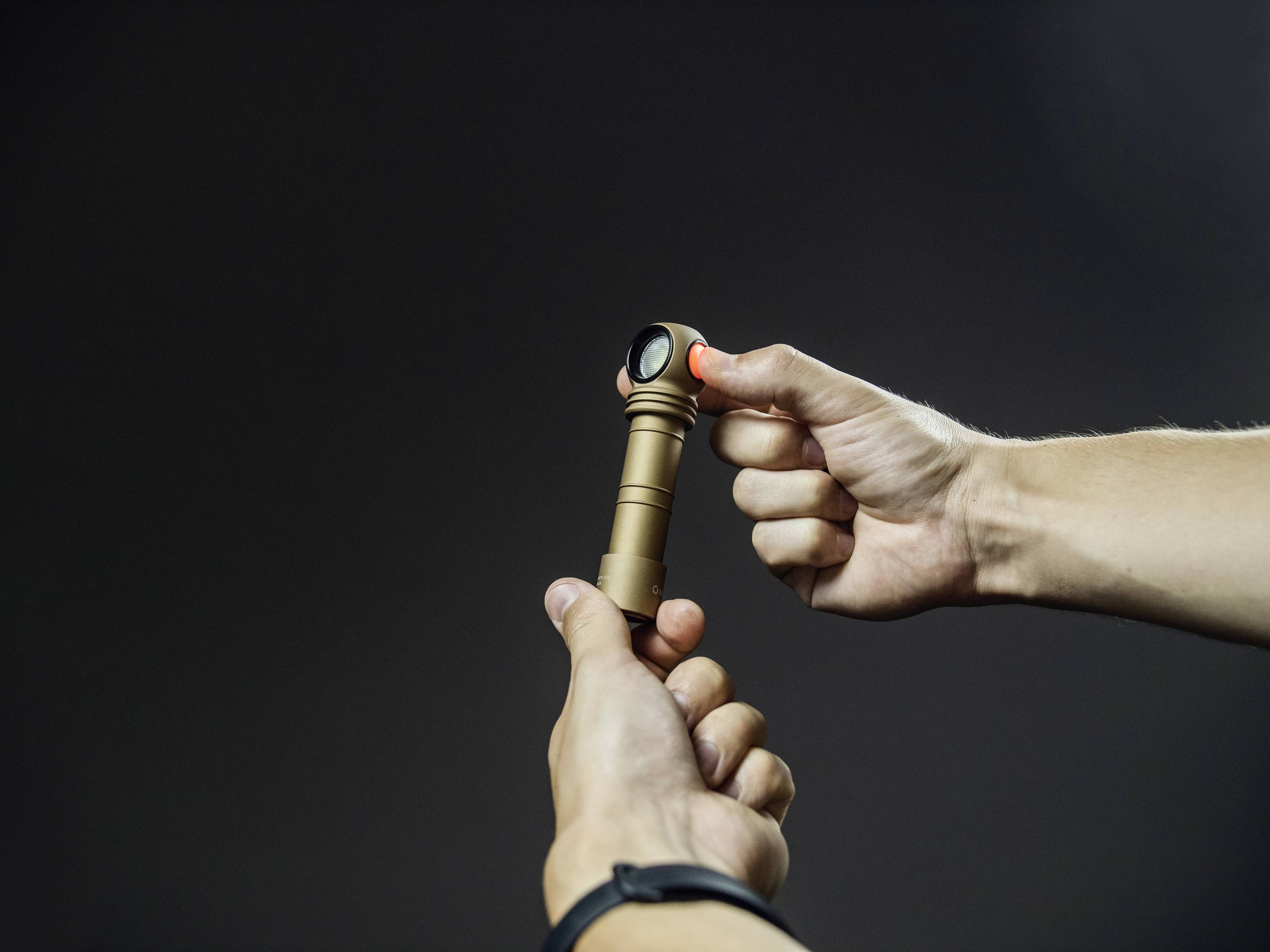 'Zwei Hände halten und richten eine Taschenlampe aus, als ob jemand ihrem Licht folgen soll. Der Hintergrund ist dunkel.'