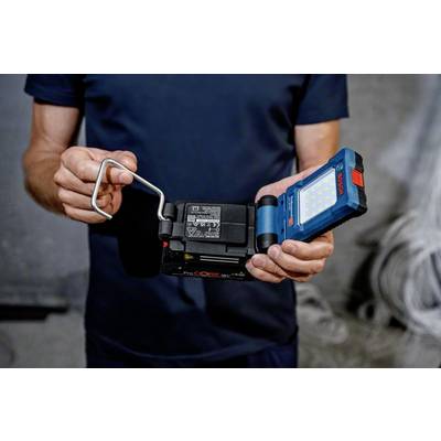 Person hält ein tragbares Arbeitsscheinwerferlicht, zeigt Rückseite mit Lade- und Batterieinformationen.