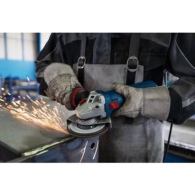 Ein Arbeiter in Schutzkleidung schleift eine Metallkante mit einem Winkelschleifer, Funken fliegen in verschiedene Richtungen.