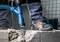 Eine Person bohrt mit einem Bosch-Bohrgerät ein Loch in eine Betonmauer. Der Boden ist staubig, ein Staubsauger ist angeschlossen.