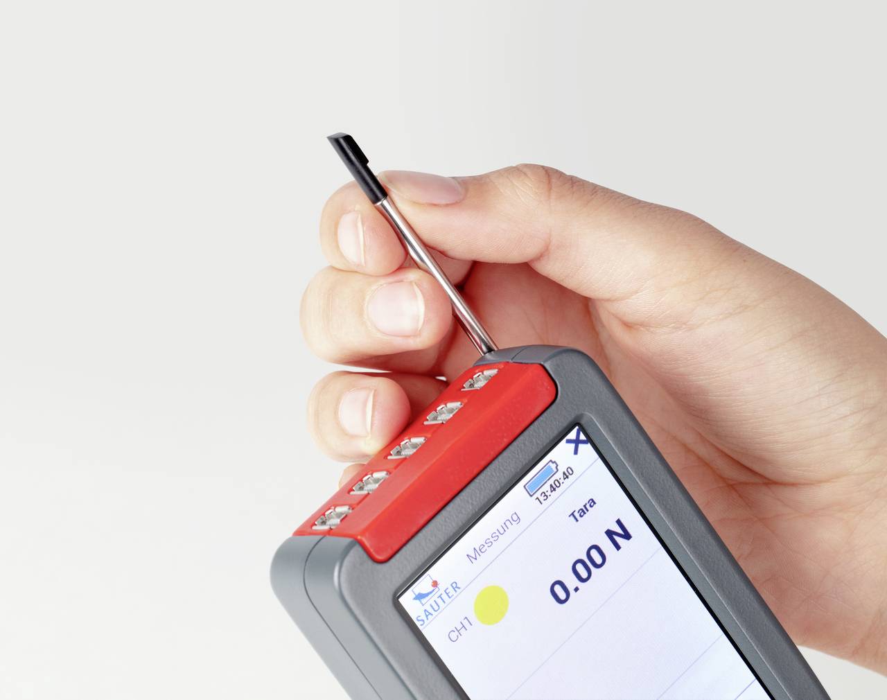 Ein Gerät zur Kraftmessung wird in einer Hand gehalten. Auf dem Display wird ein Wert von '0.00 N' angezeigt.