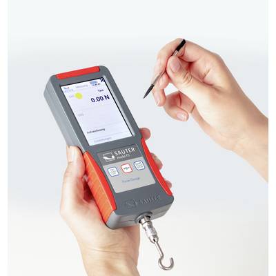 Digitale Kraftmessgerät in Hand gehalten, zeigt '0.00 N' auf dem Display. Zwei Tasten für Messung und Speicherung sichtbar.