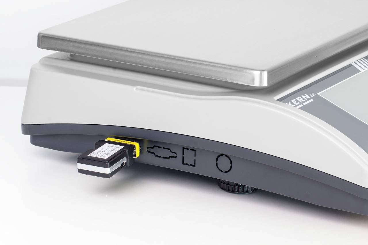 Elektronische Tischwaage mit USB-Stick in einem Anschluss. Die Wägeplattform ist sichtbar. Waage zum Wiegen von Objekten.