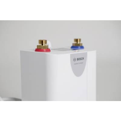 Weißer Bosch-Kompaktboiler mit zwei Anschlüssen oben, rot und blau gekennzeichnet, vor einem neutralen Hintergrund.