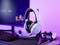 Ein Gaming-Headset steht auf einem Schreibtisch neben einer Tastatur und einem Bildschirm. Im Hintergrund ist ein Game-Controller zu sehen.
