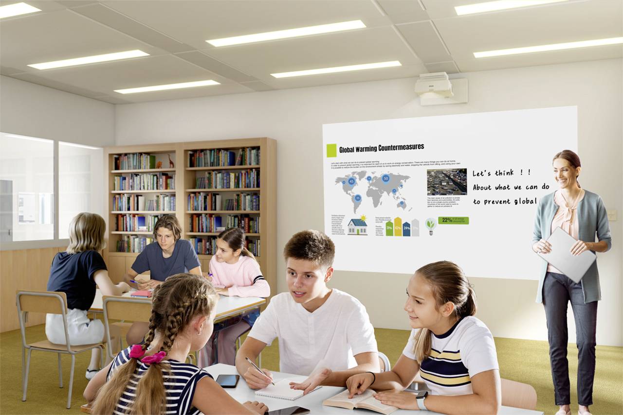 Eine Lehrerin steht vor einer Präsentation über 'Maßnahmen gegen die globale Erwärmung', während Schüler in Gruppenarbeit diskutieren.